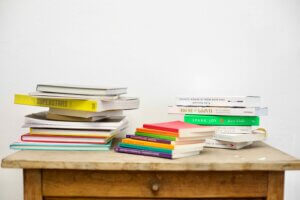 Mehrere Stapel von Büchern in unterschiedlichsten Formaten und Farben