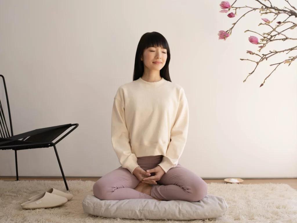 Marie Kondo in Meditationshaltung